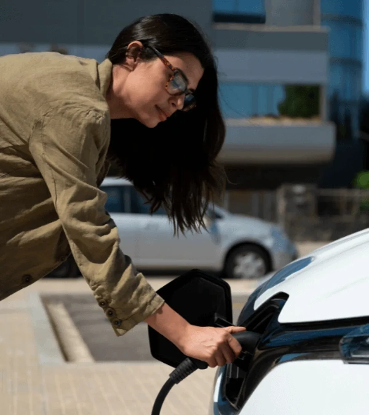 Femme rechargeant sa voiture électrique à domicile